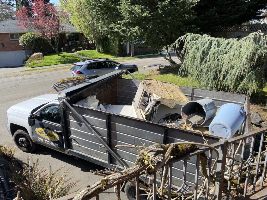 A Junk B Gone truck bed loaded with removed items and branches after a Seattle job.