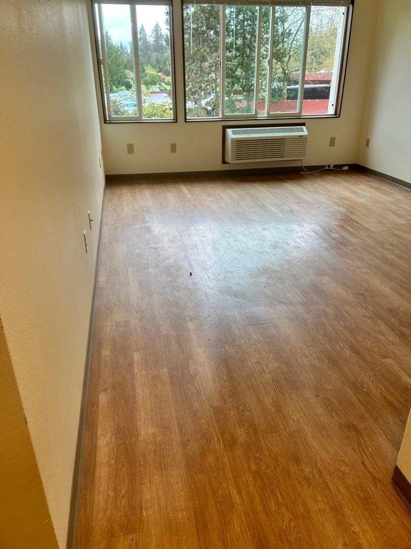 Apartment living room cleared to bare hardwood and re-lease ready at Elbert House Apartments, Bellevue