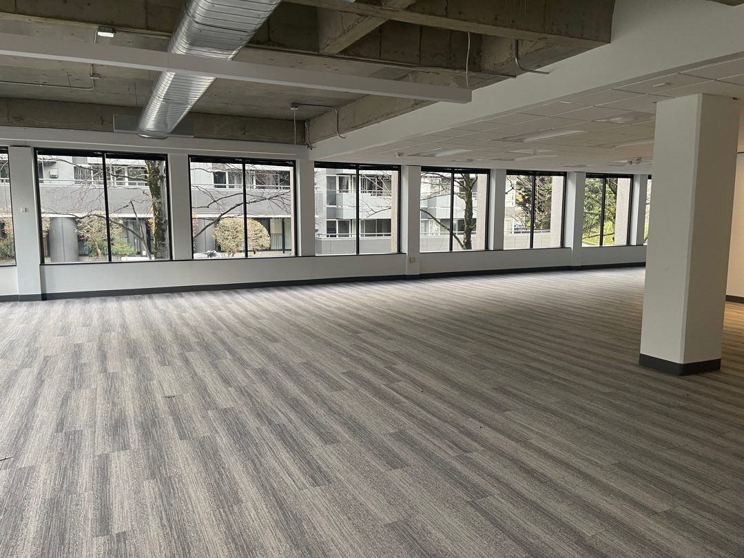 A large modern open-plan Seattle office floor cleared by Junk B Gone - wall-to-wall windows, broom-swept and ready for lease hand-back