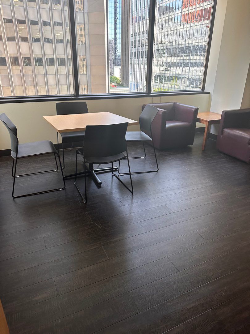 A downtown Seattle high-rise office break room cleared by Junk B Gone - table, chairs, and lounge seating with skyline windows