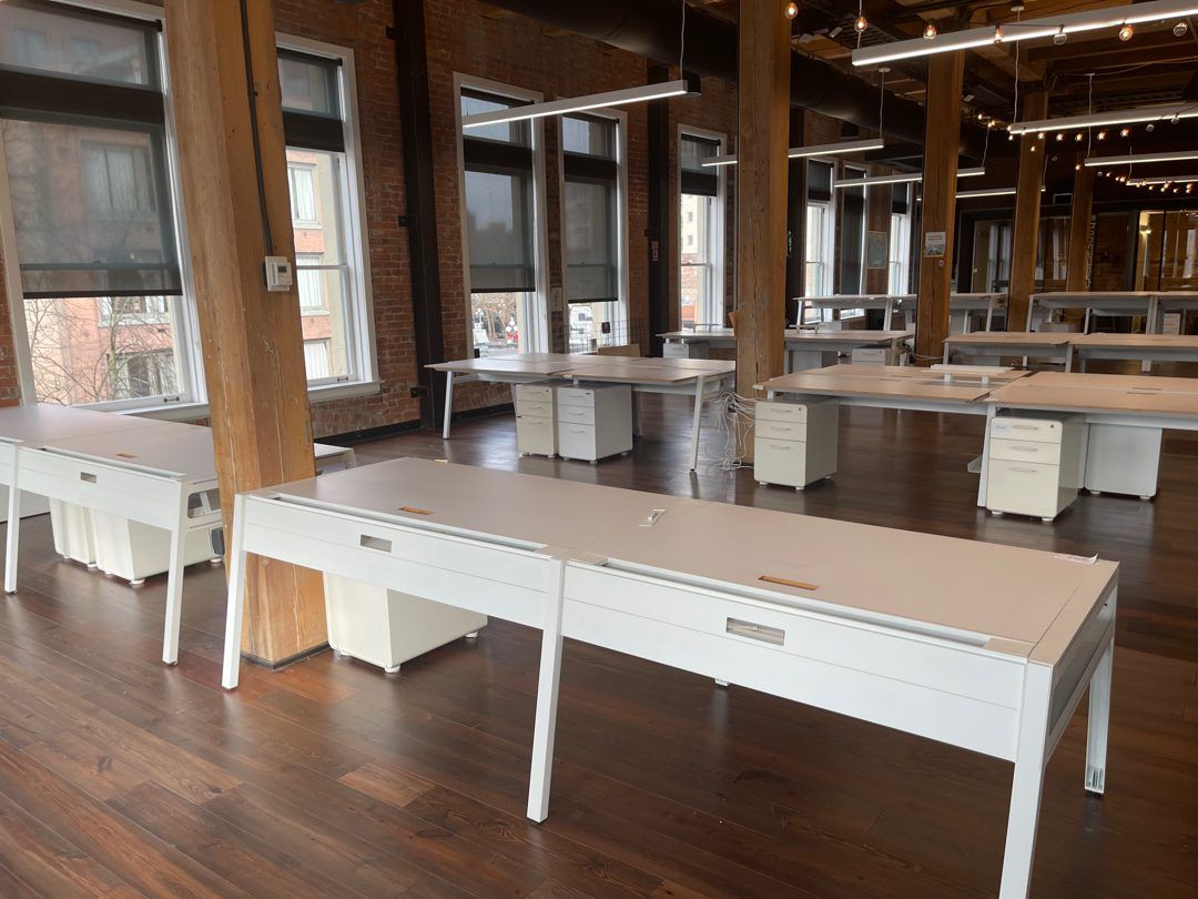 Big open Seattle loft office full of white workstation desks and file pedestals - a full floor of office furniture Junk B Gone hauls out in one visit