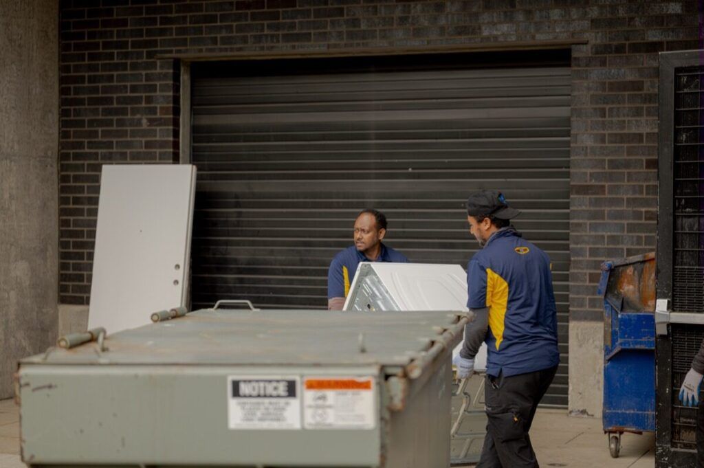 Junk B Gone crew loading washing machine at building loading dock — Seattle appliance removal