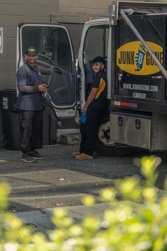 Junk B Gone team members standing by the branded junk removal truck