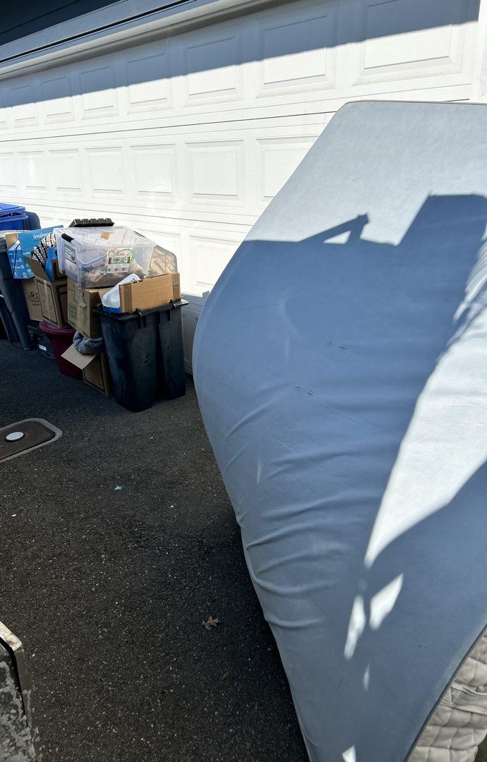 Mattress and boxed household items waiting for pickup in a North Bend driveway