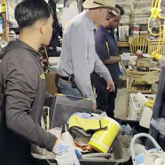 Still from a clip of the crew sorting yellow-lidded totes alongside the homeowner