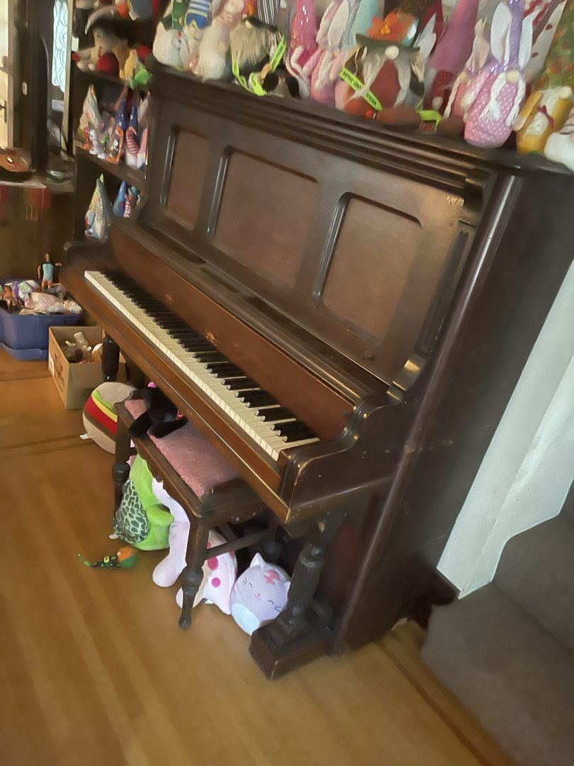 Upright piano and bench ready for removal in a Wallingford home