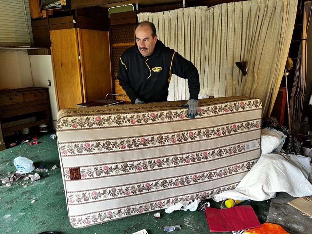Junk B Gone crew member loading a mattress for removal in Seattle