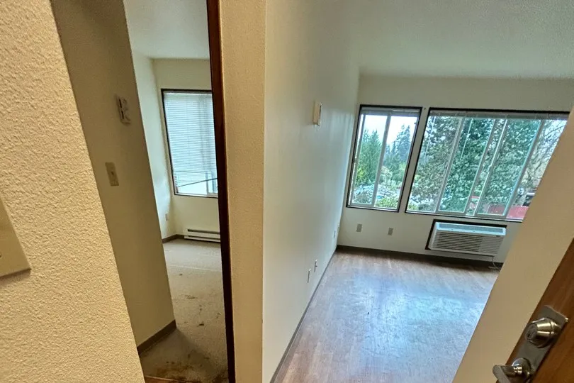 A cleared apartment with hardwood floors and bright windows, ready for the photographer.