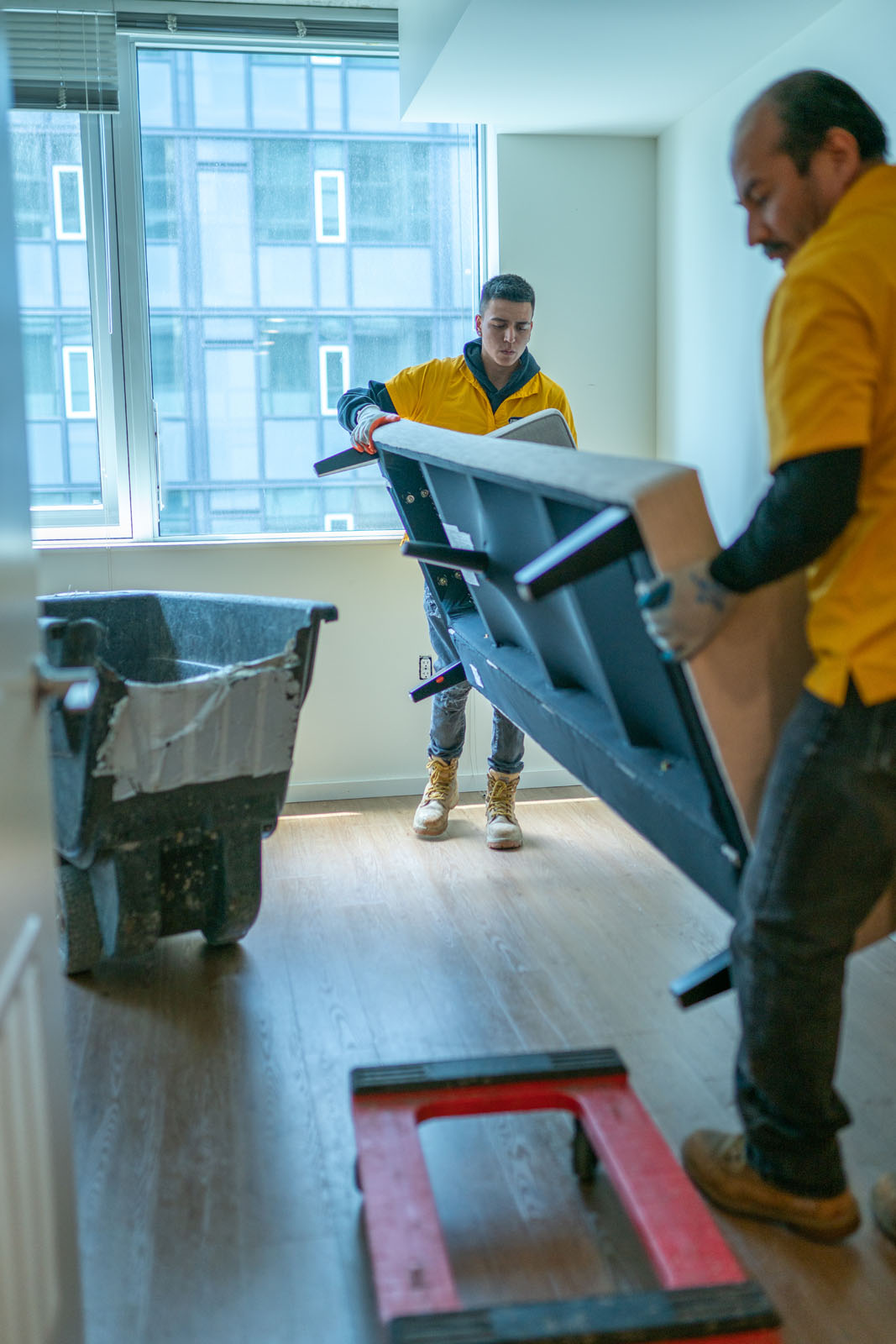 Two men remove junk furniture from a Seattle apartment