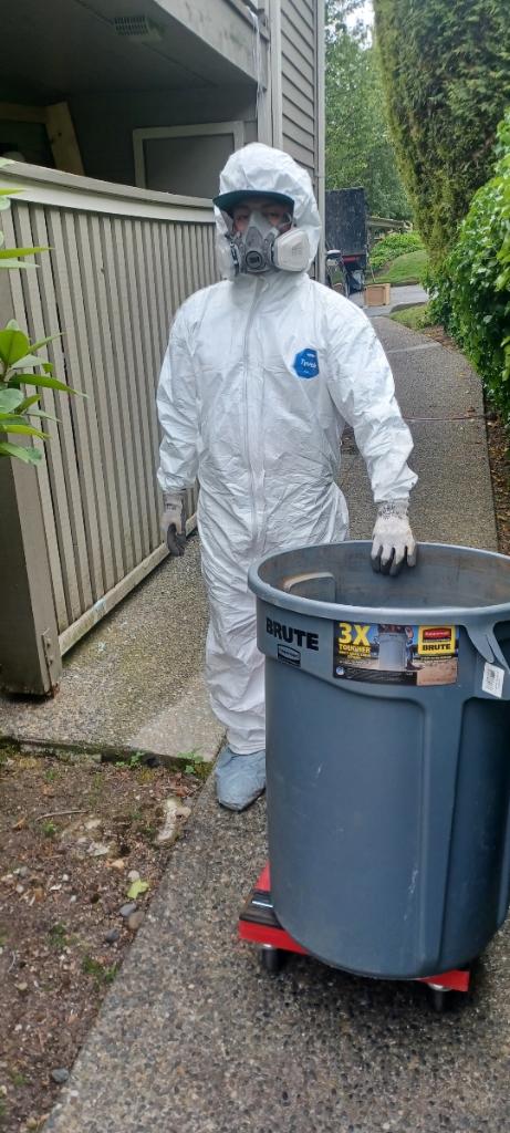 Junk B Gone employee in full protective suit and mask