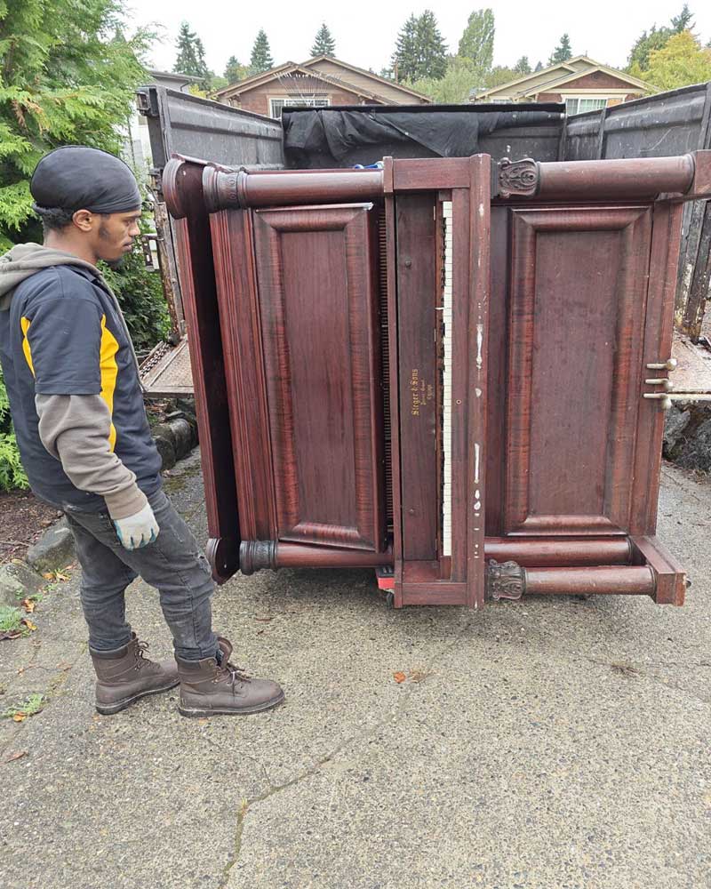 junk removal team removing an old piano