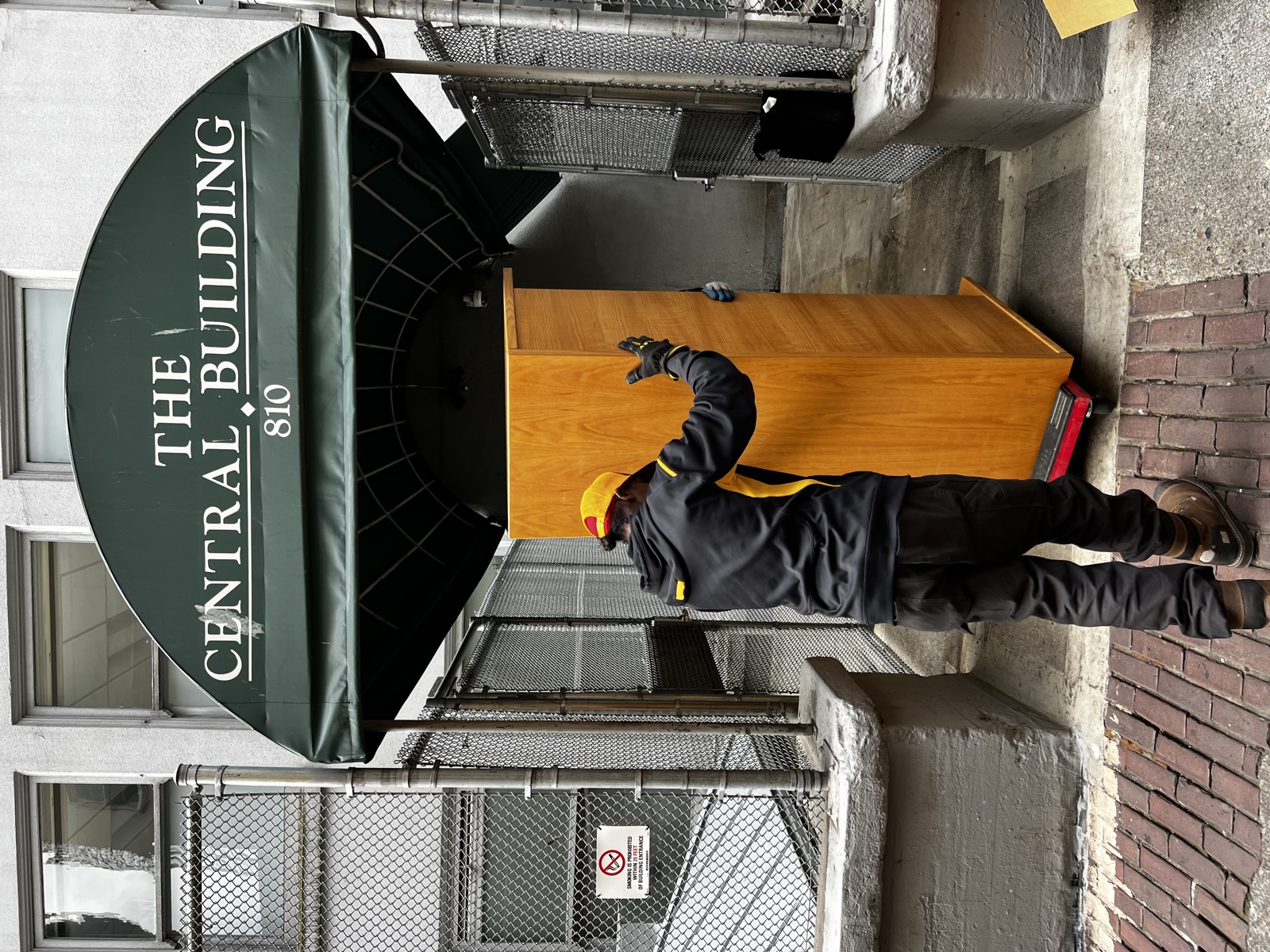 Junk B Gone crew member wheeling a desk out of The Central Building in downtown Seattle
