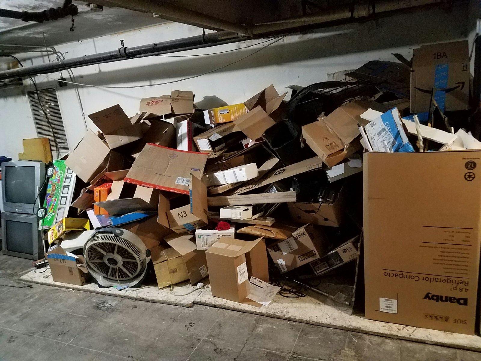 Fenced backyard area packed with cardboard boxes — a typical residential junk removal job in Seattle