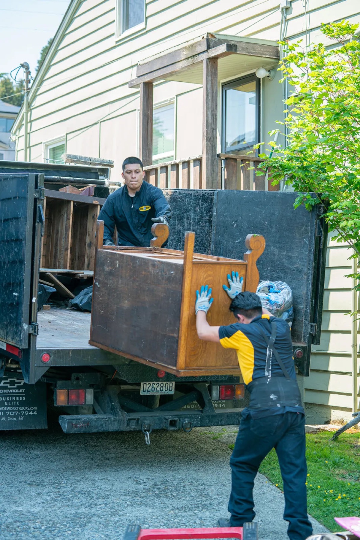Junk B Gone crew loading a wooden dresser onto the truck during residential furniture removal in Seattle